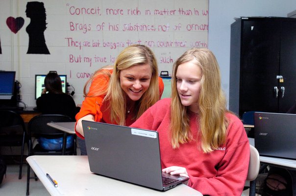 Katelyn Maresca, left, gives her student Morgan Phillips suggestions on her article for The Tide.