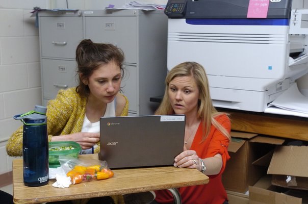 Paige Courtier, a sophomore, works on an article with her teacher, Katelyn Maresca.