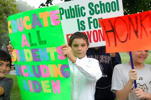 Christian Killoran, 11, holds a sign in support of his brother Aiden at a protest at Westhampton Beach Midlle School on Wednesday morning.  DANA SHAW