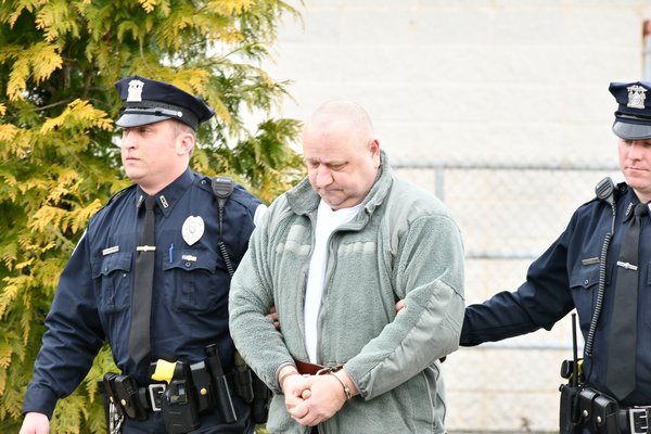 Robert Weiss is walked out of Southampton Town Police headquarters on Friday.     DANA SHAW