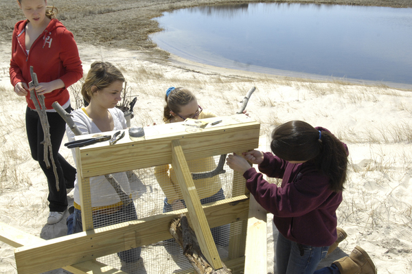 Kala Lindtbit and Rich Gostic, advisor for HOPE, measure the depth of the hole for the osprey pole.