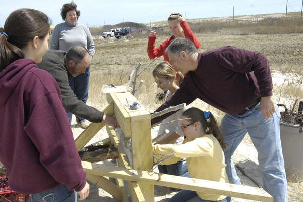 Members of HOPE, with their advisor, construct an osprey pole.