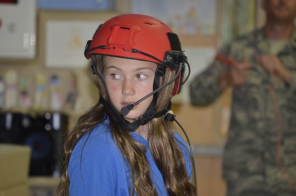 Student Ella Carriero demonstrates a helmet during a presentation with the ANG at Remsenburg-Speonk Elementary on Thursday. BY ERIN MCKINLEY