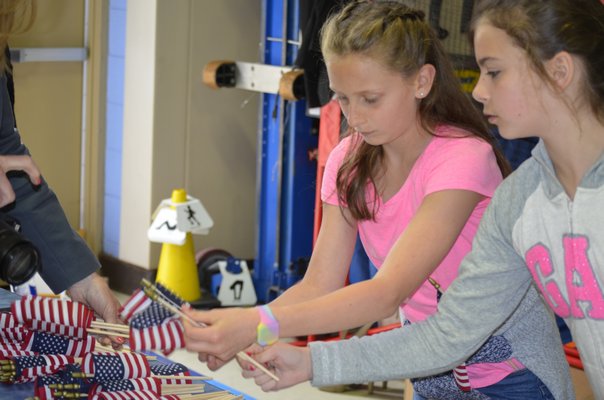 Joley Schaumloffel, left, and Cassandra Dennehy,  fifth-graders at Remsenburg-Speonk Elementary School, help stuff care packages for soldiers over seas. BY ERIN MCKINLEY