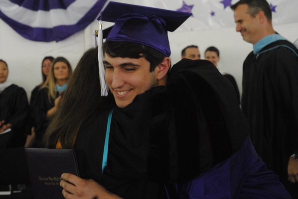 Michael Del Ray embraces Dot Capuano, a member of the Board of Education, during graduation. AMANDA BERNOCCO