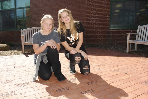 Emily Kyea, left, and her sister Brooke Kyea inside the reading garden that was dedicated to their father. AMANDA BERNOCCO