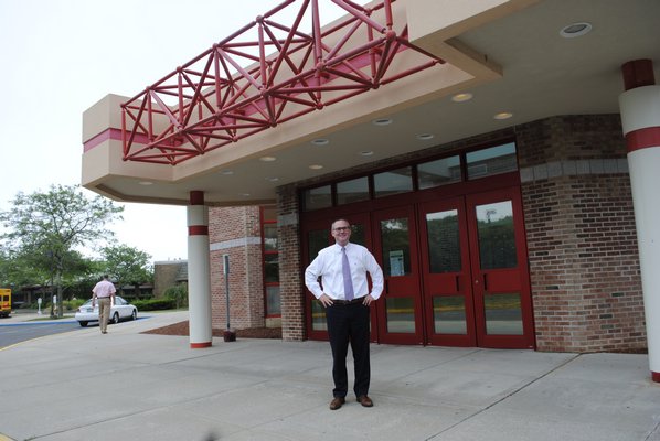 Superintendent Lars Clemensen stands in front of the enterance of the Hampton Bays High School, which will be under construction starting on June 26. AMANDA BERNOCCO