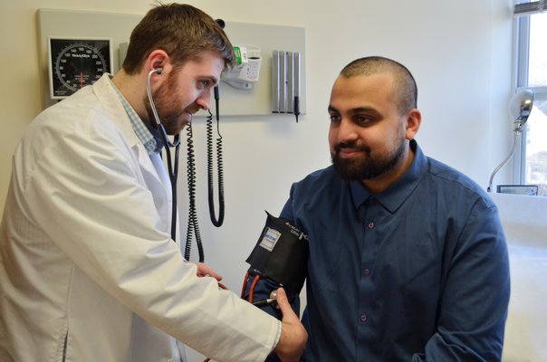 Resident physician Phillip Berges practicing taking vitals on fellow resident physician Bassam Hossain. ANISAH ABDULLAH
