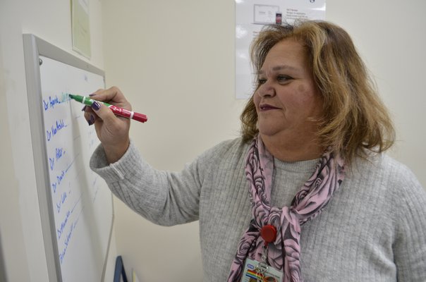 Westhampton Primary Care Center Site Administrator Maria Barlowe informing patients which doctors are in that day on a white board displayed in the waiting room. ANISAH ABDULLAH