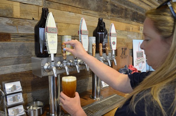 Co-owner Kate Tedesco pouring a beer at Westhampton Beach Brewing Company. ANISAH ABDULLAH