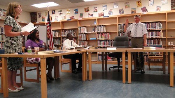 Tuckahoe School District Clerk Linda Springer swears in School Board Chairman Robert Grisnik on Monday, July 11, for a second straight term.