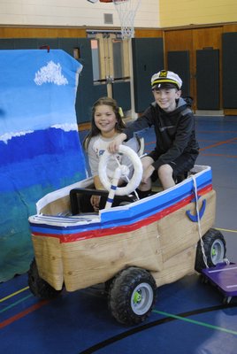 Alexandra Garcia and Ethan Vogt display a boat prop made by their team for the Odyssey of the Mind competition. BY ERIN MCKINLEY
