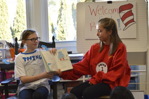 Tuckahoe School sixth-grade students Hallie Beeker, left, and Ellie Hattrick read "The Cat in the Hat" to Ms. Merriam's fourth grade class to celebrate Dr. Seuss Week at the school. ALYSSA MELILLO