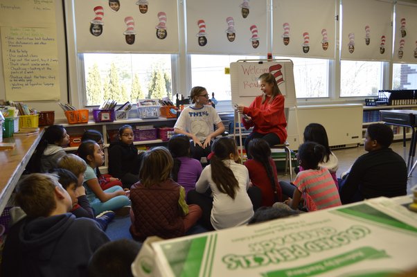 Tuckahoe School sixth-grade students Hallie Beeker, left, and Ellie Hattrick read "The Cat in the Hat" to Ms. Merriam's fourth grade class to celebrate Dr. Seuss Week at the school. ALYSSA MELILLO