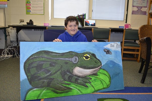 Alex Spizuoco, 11, shows a celing tile he helped paint at Westhampton Beach Elementary School. BY ERIN MCKINLEY