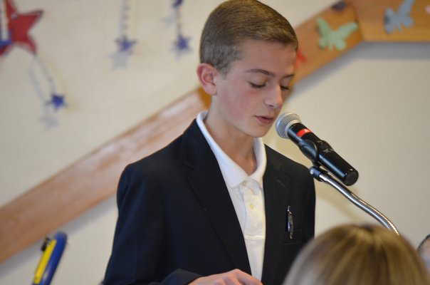 Connor Rozzi reads his patriotic speech at a Veteran's Day breakfast at the Tuckahoe School on Monday. BY ERIN MCKINLEY