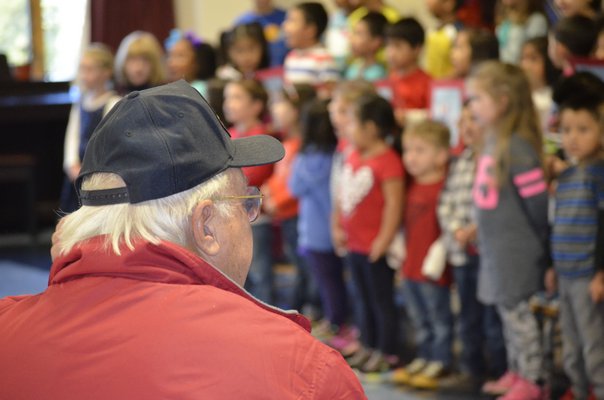 A local veteran watches as Tuckahoe students sing patriotic songs during a Veteran's Day breakfast on Monday morning. BY ERIN MCKINLEY