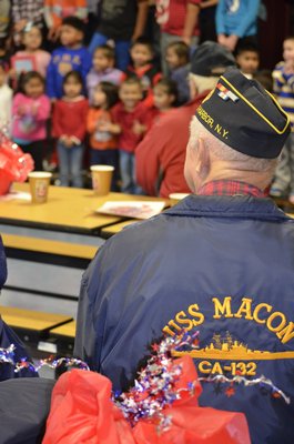 A local veteran watches as Tuckahoe students sing patriotic songs during a Veteran's Day breakfast on Monday morning. BY ERIN MCKINLEY