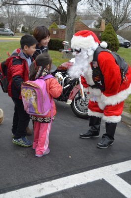 From left, Ying Kwok and her children, Evan and Maggie with Santa outside East Quogue Elementary School. ALEXA GORMAN