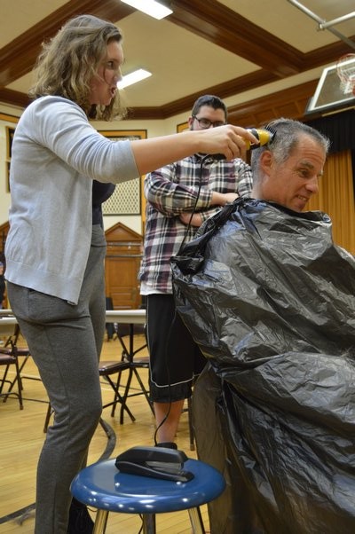 Bridgehampton School Senior Hayley Lund shaves teacher John Reilly's head on Friday. ALYSSA MELILLO