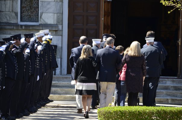 Edward Corrigan's family enter the church with his casket. ANISAH ABDULLAH