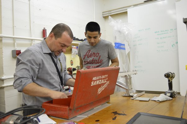 Ken Giosi, left, faculty advisor for the Bridgehampton Robotics team, and team co-captain Claudio Figueroa prepare to work on a robot part earlier this week at the Bridgehampton School.