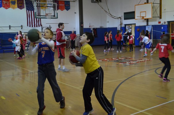 Fifth-graders Jake Bertorello, left, and Griffin Schevrer participated in the annual "Hoops for Heart" fundraiser at East Quogue Elementary School on Friday. ALEXA GORMAN