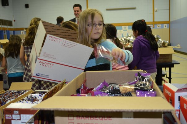 Brielle Bremerman, third-grader at Remsenburg-Speonk Elementary School, packs a box to send to deployed troops. ALEXA GORMAN