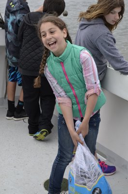 Duygu Mete, a sixth-grader at East Quogue Elementary School, hauls clams to be dumped into Tiana Bay. ALEXA GORMAN