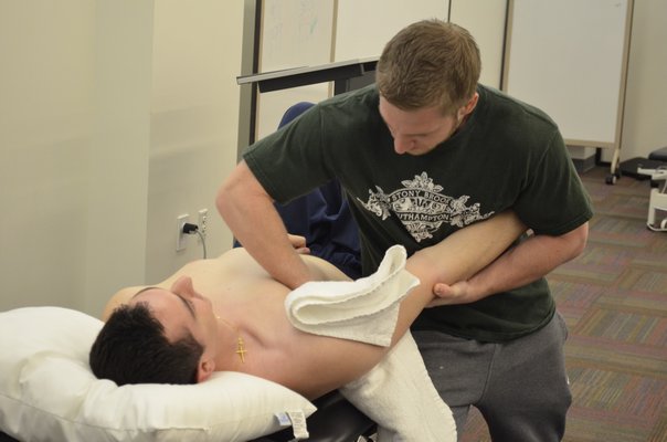 Second year physical therapy student John Kudreyko practices a shoulder joint mobilization technique on his classmate, Nick Byrne. BY ERIN MCKINLEY