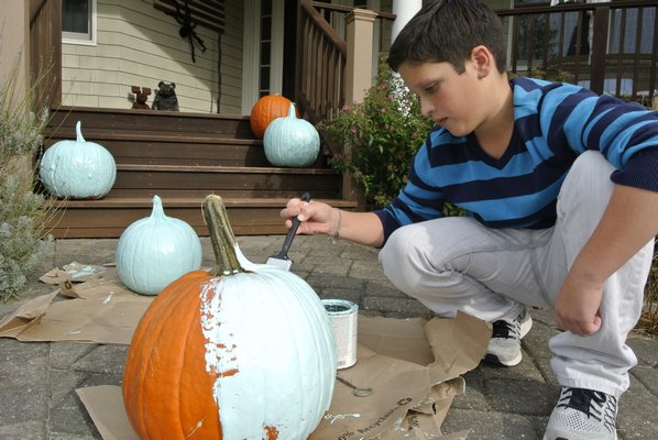 Ethan Gates, who suffers from an allergy to tree nuts and peanuts, paints a pumpkin for the Teal Pumpkin Project, a national campaign by the Food Allergy Research & Education organization to raise awareness about food allergies and help to include all children in the Halloween festivities.   DANA SHAW