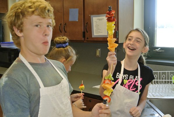 Timmy Hurley and Katey O'Brien make fruit kebabs.
