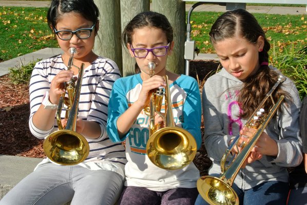 Fourth graders Sarah Ren, Stephanie Parriles, Valentina Vega play with instruments donated to their school. DANA SHAW
