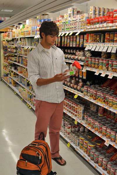 Aiden Kravitz looks for canned foods that can be included in the backpacks for hungry children. ERIN MCKINLEY