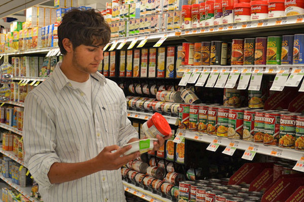 Aiden Kravitz looks for canned foods that can be included in the backpacks for hungry children. ERIN MCKINLEY
