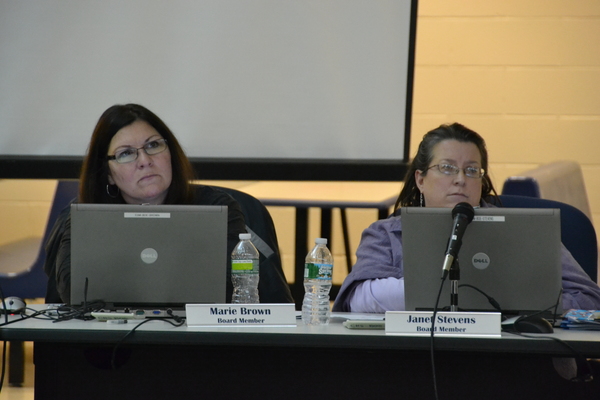 School board members Marie Brown and Janet Stevens look on as community members address the board at Wednesday night's meeting. LAURA COOPER