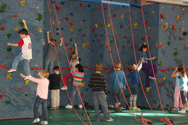 Westhampton Beach elementary students show off how they learned how to traverse, or climb side-to-side, on the rock climbing wall.