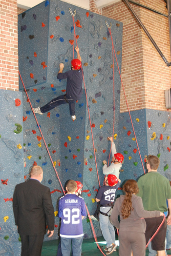 Elementary School principal Ron Masera, left, and teacher Sean Montpetit climb up the wall with the help of elementary school students.