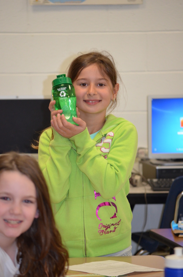 Edona Popi holds up her reusable water bottle during class.