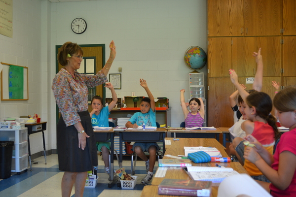 East Quogue Elementary School teacher Rosemary Enners raises her hand alongside her third grade class next week.