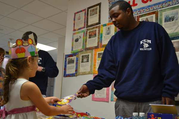 A first grade student at the South Street School receives a prize at the Star Mart from James McClease, a special education student at the Eastport South Manor Junior-Senior High School.