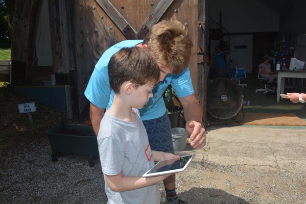 Campers use ipads to calibrate drones.