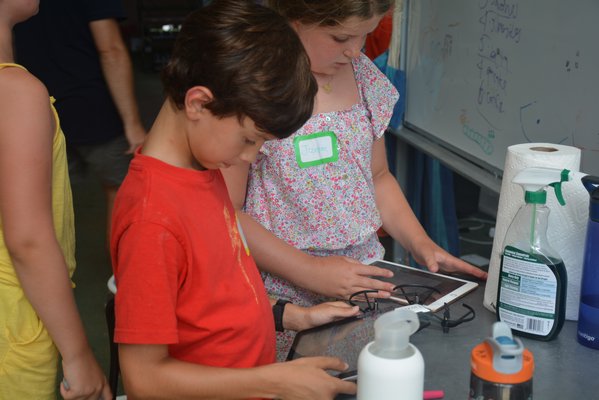 Campers use ipads to calibrate drones.