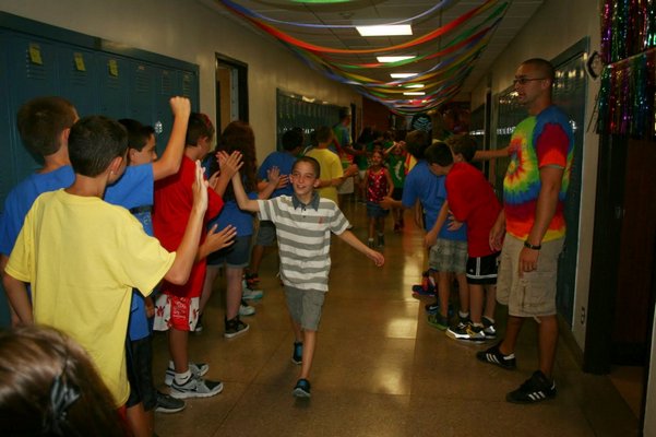 Sean Antonucci high-fives students on the first day of school. COURTESY EASTPORT ELEMENTARY SCHOOL