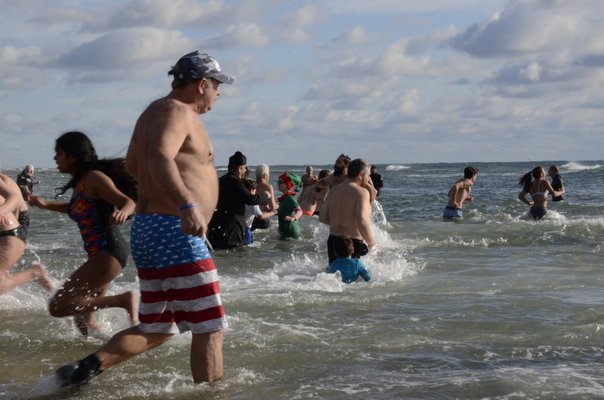 People ran in and out of the 47 degree water for the 13th annual Polar Bear Plunge at Coopers Beach in Southampton on Saturday. BY GREG WEHNER