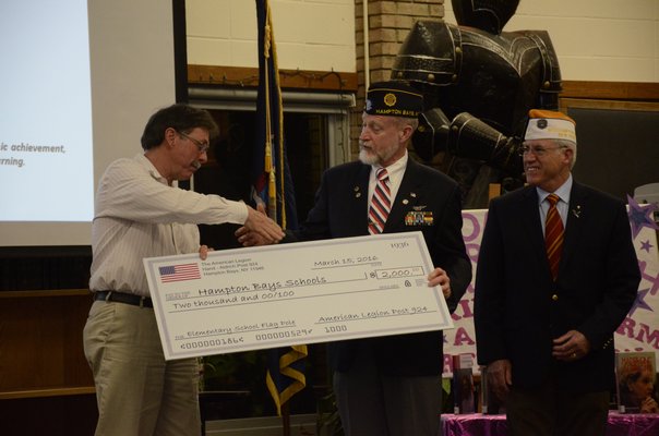 Members of the American Legion Hand-Aldrich Post 924 present a $2,000 check to the Hampton Bays Board of Education at Tuesday night's meeting, to replace a flag pole in front of the elementary school that was blown down in a snow storm in February. Pictured left to right, Hampton Bays Board of Education President Rich Joslin, Richard Steiber and William Hughes. GREG WEHNER