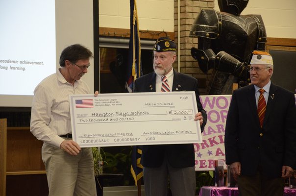 The Hampton Bays Board of Education receives a check for $2,000 from the American Legion Hand-Aldrich Post 924 during the Board of Education meeting on Tuesday night. Pictured left to right, Board of Education President Rich Joslin, Richard Steiber and William Hughes. GREG WEHNER