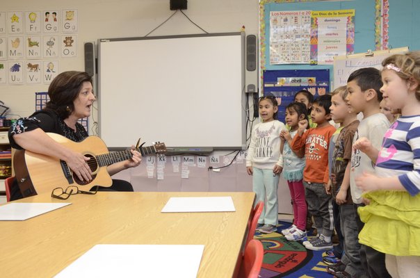 Madelyn Liso, who works with the school district music department at the elementary school, plays music to the bilingual kindergarten class a couple of times a week. GREG WEHNER