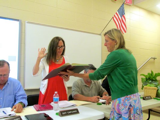 Dorothy "Dot" Capuano is sworn into her second term on the Hampton Bays Board of Education by district clerk Anna Rojas during the board's reorganizational meeting on Tuesday night. KYLE CAMPBELL