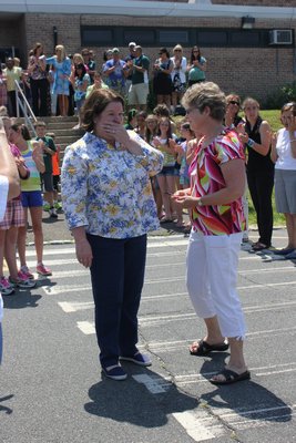 Nancy Cummings, left, a secretary at the Westhampton Beach Elementary School, and kindergarten teacher Eloise Carter react to the warm goodbye the students, faculty and parents gave them on their last day before retirement. BY CAROL MORAN